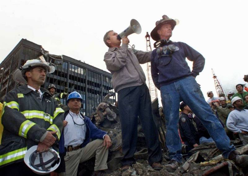 President George W. Bush addresses a crowd alongside retired firefighter Bob Beckwith at the remains of the World Trade Center collapse in September 2001.
