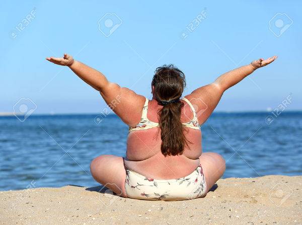 33153876-overweight-woman-sitting-on-beach-with-hands-up-Stock-Photo-fat.jpg