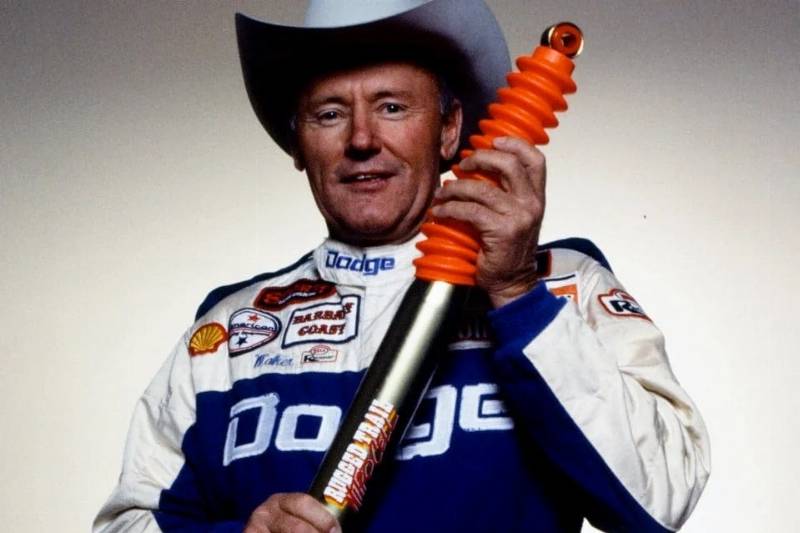race car driver holding a suspension shock absorber