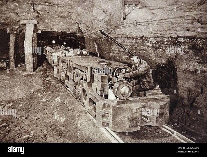 an-early-photograph-in-a-coal-mine-showing-the-introduction-of-motorised-trains-to-transport-t...jpg