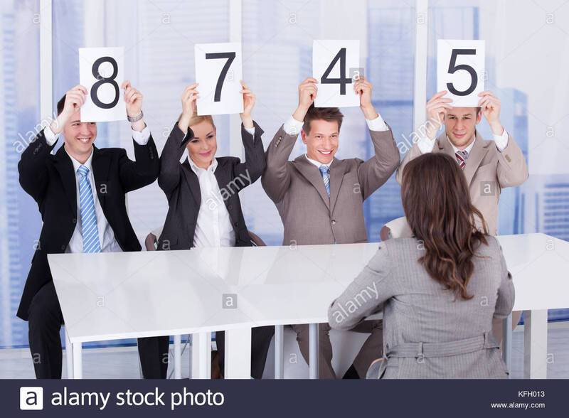 business-people-showing-score-cards-in-front-of-female-candidate-during-KFH013.jpg