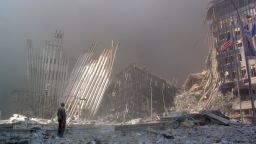 (FILES) This 11 September 2001 file photo shows a man standing in the rubble, and calling out asking if anyone needs help, after the collapse of the first World Trade Center Tower in New York City. AFP PHOTO/Doug KANTER (Photo credit should read DOUG KANTER/AFP/Getty Images)