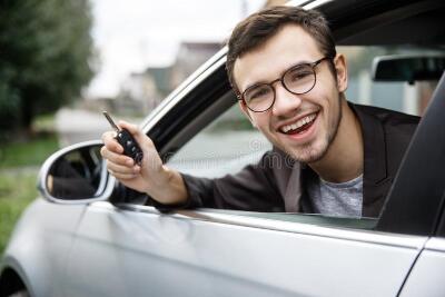 isfied-young-guy-peeking-car-window-looking-camera-holding-keys-his-right-hand-lottery-140171374.jpg