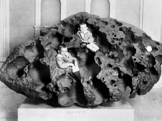 Two boys sit inside Willamette, an iron meteorite weighing 14500 kg..jpg