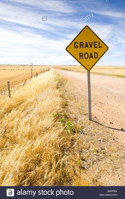 gravel-road-road-sign-warning-of-loose-stones-on-the-ground-surface-BA0TM4.jpg